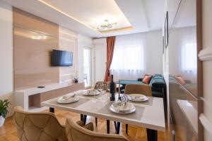 a dining room and living room with a table and chairs at Apartman Vanilla Sky in Trebinje