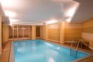 a swimming pool in a hotel room with columns at Hotel Portavescovo in Arabba