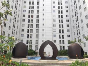 a sculpture in front of a tall building at Moagi Stay Alamanda - Netflix Ready! in Jakarta