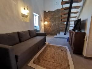 a living room with a couch and a television at Chão da Velha - Casas de Campo in Nisa