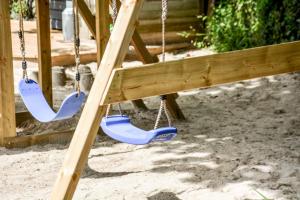 a swing set with two swings in a playground at Lower Trengale Farm Holiday Cottages in Liskeard +16 photos