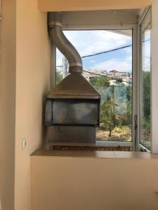 cocina con fogones y ventana en georgia's cozy rooms #1, en Kavala