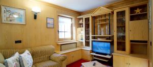 a living room with a couch and a television at Bait da Marieta in Livigno