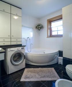 a bathroom with a tub and a washing machine at Bait da Marieta in Livigno +5 photos