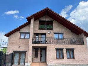 a brick house with a balcony on top of it at Casa OLD BRICK in Ocna Şugatag