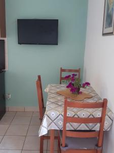 a table with two chairs and a television on a wall at Apartman Burte, Komiža in Komiža