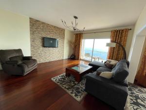 a living room with a couch and chairs and a television at Villa Isabela - Car Rental for Free in Caniço
