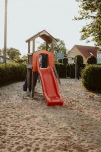 um parque infantil com um escorrega vermelho na areia em Modernisiertes Fachwerkhaus in Rheinbach bei Bonn em Rheinbach