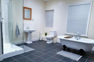 a bathroom with a tub and a toilet and a sink at Coastal escape in the heart of Saltburn in Saltburn-by-the-Sea +12 photos