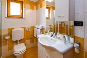 a bathroom with a sink and a toilet at Apartments Smiljanic in Tribunj +106 photos