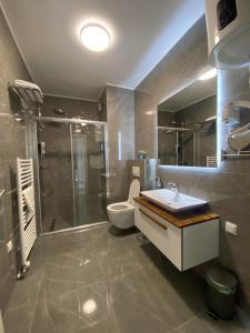 a bathroom with a shower and a toilet and a sink at Fontana apartmani FREE parking in Tuzla