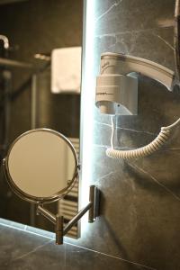 a mirror and a hair dryer in a bathroom at Fontana apartmani FREE parking in Tuzla