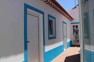 a row of blue and white houses with a door at Sudoeste Guest House in Odeceixe