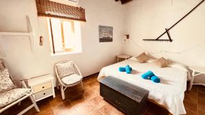 a bedroom with two beds and a chair and a window at Casa Can Pep Tauet in San Ferrán de ses Roques