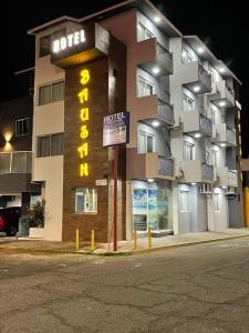 a building with a hotel sign in front of it at Hotel & Suites Bausan in Boca del Río