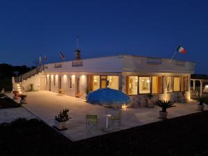 a house with an umbrella in front of it at night at Villa Fumarola in Ostuni