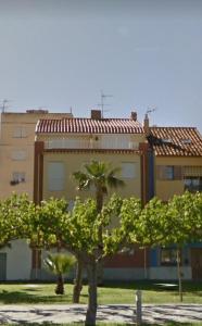 un edificio con una palmera frente a un edificio en Dúplex playa Torrenostra, en Torreblanca