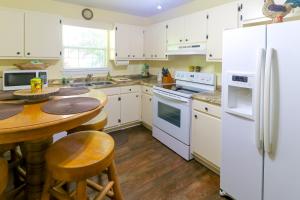 a kitchen with white appliances and a wooden table at Little Bear Retreat 1 in Helen