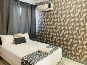 a bedroom with a bed and a wall at Hotel & Suites Bausan in Boca del Río +11 photos