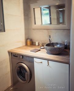 a bathroom with a sink and a washing machine at Appartement Chalet Les hauts du soleil in Chamonix