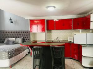 a kitchen with red cabinets and a bed in a room at Hotel & Suites Bausan in Boca del Río