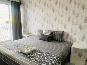 a bedroom with a bed with pink flowers on the wall at Hotel & Suites Bausan in Boca del Río