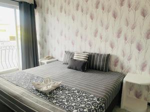 a bedroom with a bed with pink flowers on the wall at Hotel & Suites Bausan in Boca del Río +8 photos