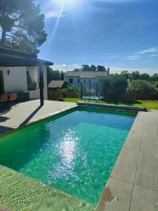 einen Pool mit blauem Wasser im Hof in der Unterkunft Villa Echappé à 15 min de la mer in Cournonsec