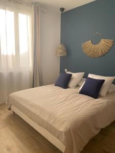 a bedroom with a large bed with blue walls at Cassis centre, superbe appartement neuf, 50m port. in Cassis