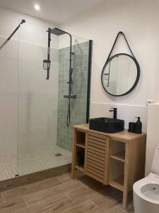 a bathroom with a shower and a sink and a mirror at Cassis centre, superbe appartement neuf, 50m port. in Cassis
