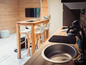 a room with a desk and a table with a sink at Appartement Chalet Les hauts du soleil in Chamonix