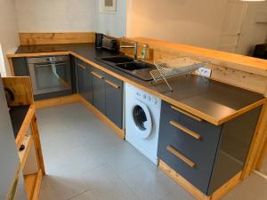 een keuken met een wastafel en een wasmachine bij Appartement douillet Lorgues in Lorgues