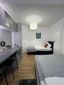 a room with two beds and a table in it at S&M Villa Kolobrzeg in Kołobrzeg