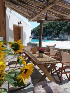 a wooden table and chairs on a patio with a beach at Κυμοθόη in Milopotamos