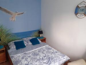 1 dormitorio con 1 cama con un pájaro volando sobre él en APARTAMENT LAZUROWY en Władysławowo