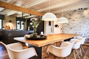 a dining room with a wooden table and white chairs at MeinNest31 in Sankt Peter-Ording