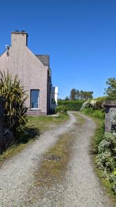 een onverharde weg naar een huis bij Room by the Beach in Aird Tong