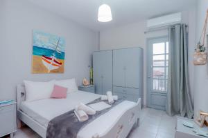 una camera da letto con un letto con lenzuola bianche e cuscini rosa di Calma Luxury Apartments #3 Sozopoli in Halkidiki a Sozopoli