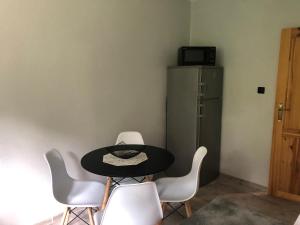 a table and chairs in a room with a refrigerator at Apartament KOMPAS in Świeradów-Zdrój