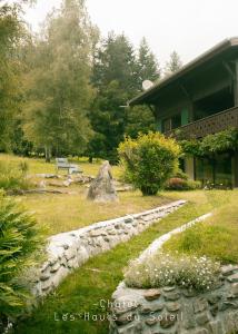 a garden with a stone path in front of a house at Appartement Chalet Les hauts du soleil in Chamonix