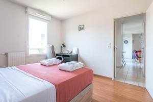 um quarto com uma cama com duas toalhas em La loge du Minotaure, parking et bureaux em Toulouse