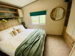 a small bedroom with a bed and a mirror at The Sanctuary Holiday Home - Escape the Ordinary in Knaresborough