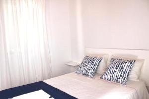 a bedroom with a bed with two pillows on it at Sudoeste Guest House in Odeceixe