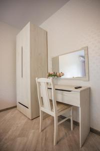 a white desk with a chair and a mirror at Семейные апартаменты в Агудзере in Sukhum