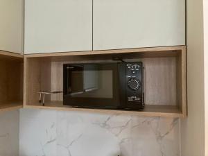 a microwave oven sitting on a shelf in a kitchen at przytulnie w Łodzi in Łódź