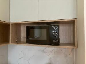 un forno a microonde seduto su uno scaffale in cucina di przytulnie w Łodzi a Łódź Altre 13 foto