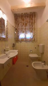 uma casa de banho com 2 lavatórios, um WC e uma janela em Villa Lisa em Duna Verde