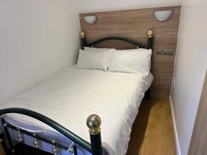 uma cama com lençóis brancos e almofadas num quarto em Entire Two Bedrooms Flat with Nice View H2 em Great Yarmouth