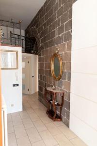 a hallway with a mirror on a brick wall at Ercole Luxury Flat in Sessa Aurunca