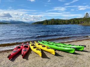 4 kayaks alineados en la orilla de un lago en Big River Camp Hotel & Spa en Föllinge